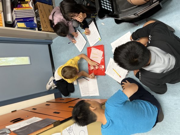5 5th-grade students engaged in collaborative work