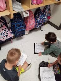 Three students engaged in a literacy activity