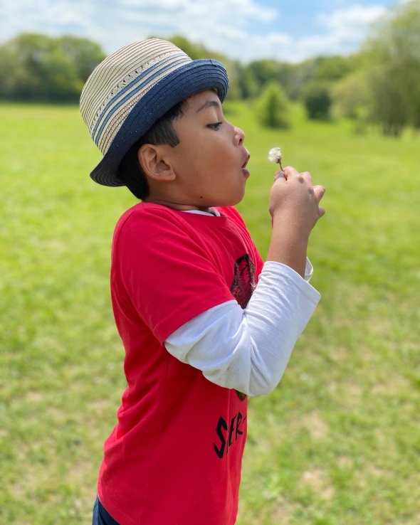 3rd grade student blowing a dandelion