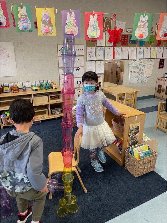children using plastic cups for building