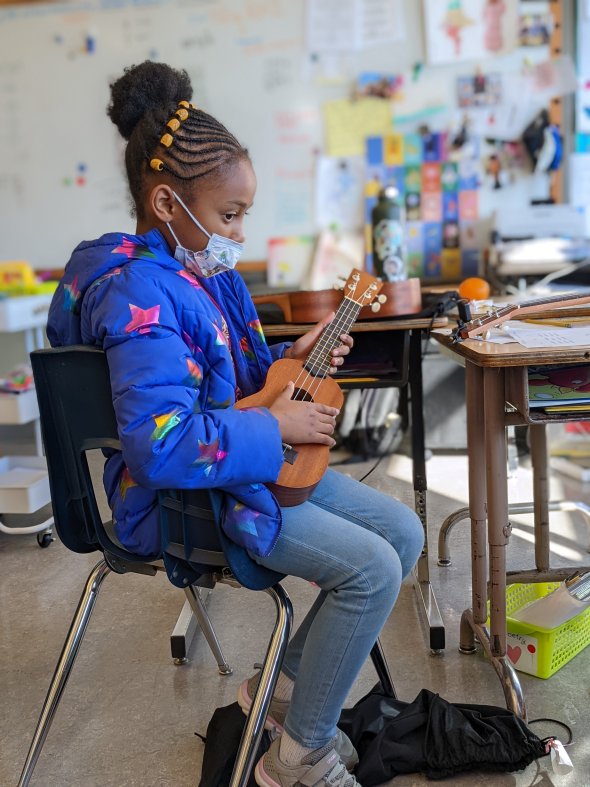 2nd grade student playing a ukulele