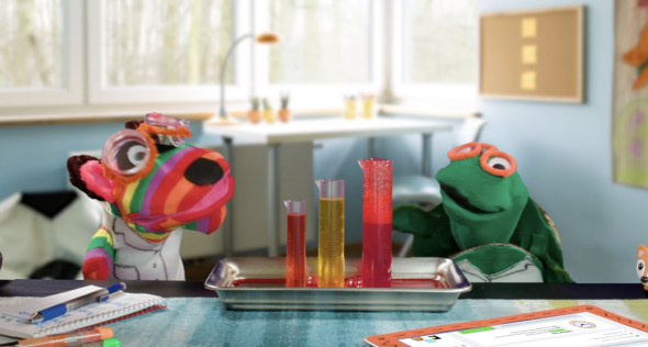image of two puppets talking about science with beakers