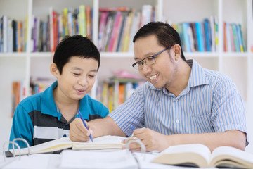 a student and a parent sitting side by side looking at a binder