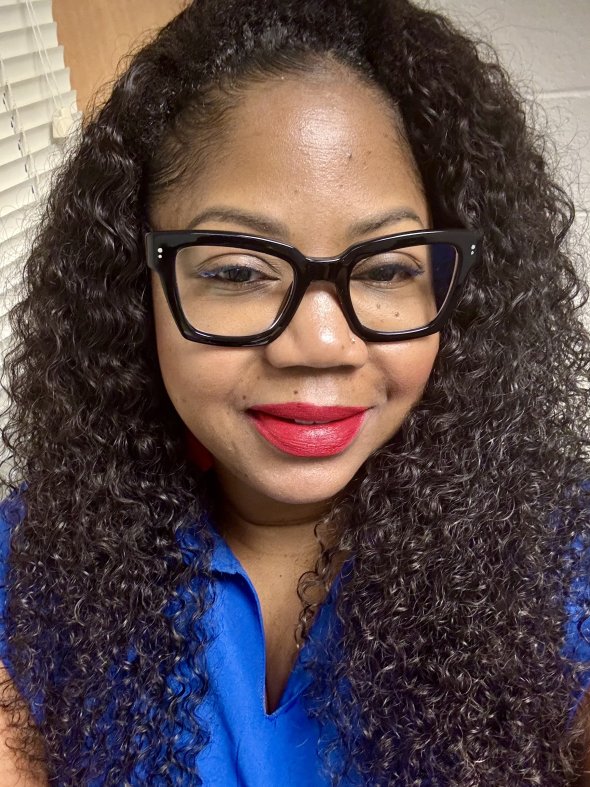 Portrait of a woman with red lipstick, glasses and curly brown hair
