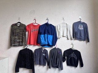 9 jackets from lost & found hanging on wall