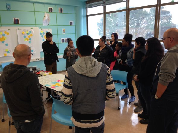 A Group discussion with both teachers and students circled around a table.