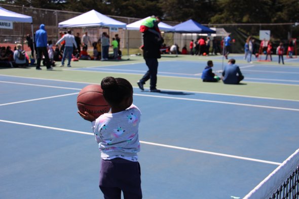 Little girl playing basketball at Special Olympics