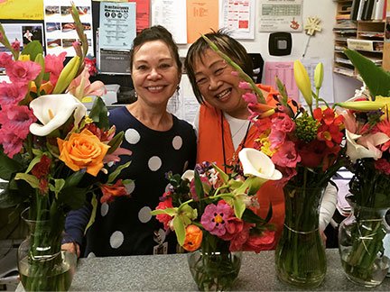Two female school employees posing with flowers
