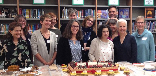Authors standing in front of a cake