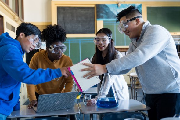 A group of high school students work together on a science project.