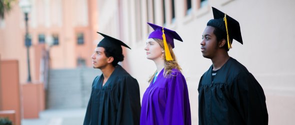three students in caps and gowns