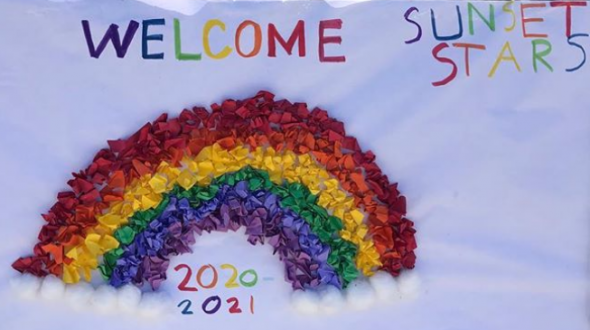 Sign with a rainbow that says "Welcome Sunset Stars"