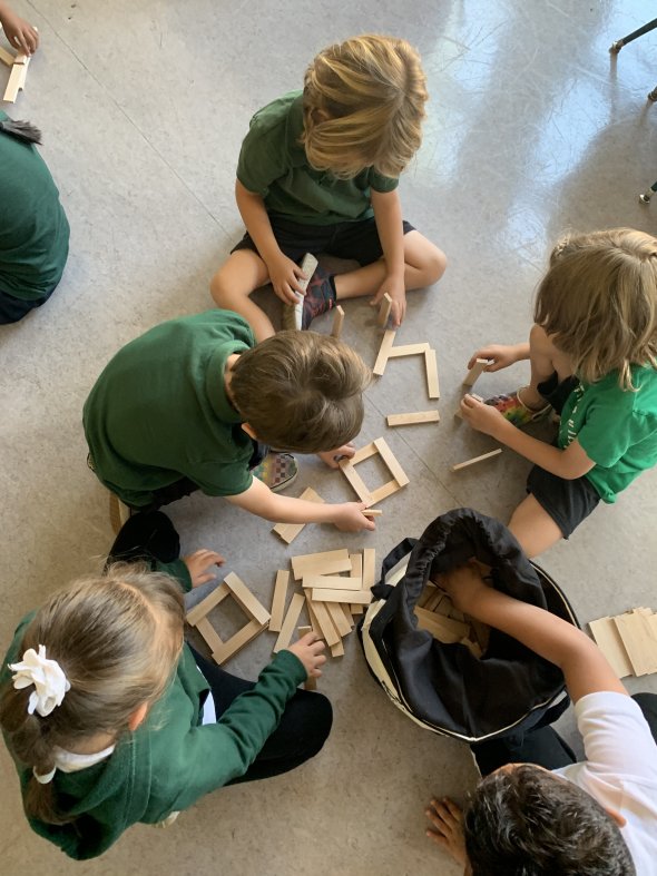 Four students playing blocks on the floor