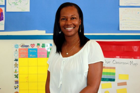 Teacher smiling at camera in her classroom