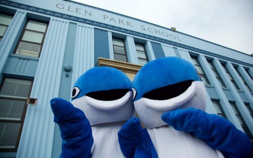 Two students in whale costumes in front of Glen Park School 