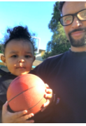 Photograph of Mr. Proctor with his child holding a basketball  
