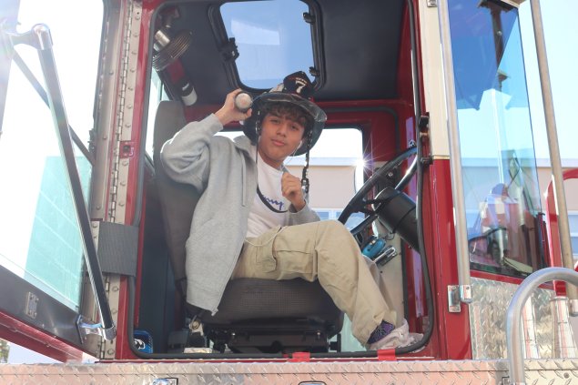 Student sitting in fire truck.