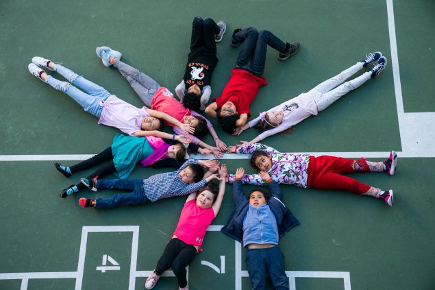 Students lying in the schoolyard to form a circle