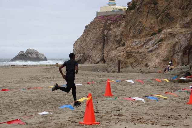 Middle school student running on ocean beach 