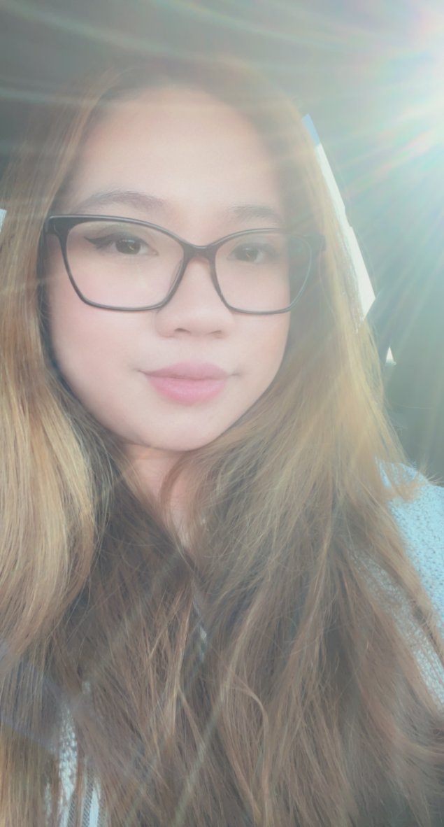 Asian female, light brown hair, wearing glasses, with light shining in photo