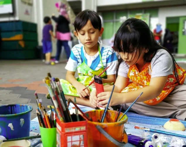 Two 4th-grade students working on a shared art project