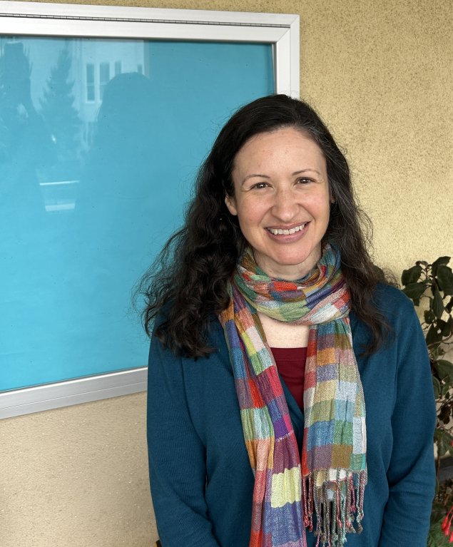 Smiling white woman with long brown hair and a scarf