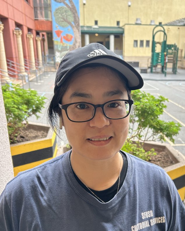smiling asian woman with cap on