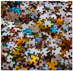 Tons of different colored puzzle pieces piled up 