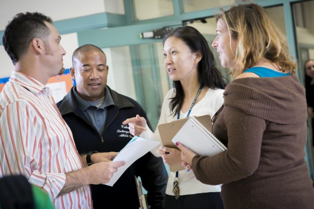 Adults meeting in a hallway