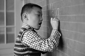 boy writing on blackboard