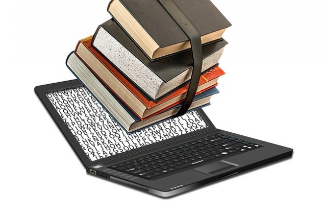Open laptop with a bundle of books attached to the screen