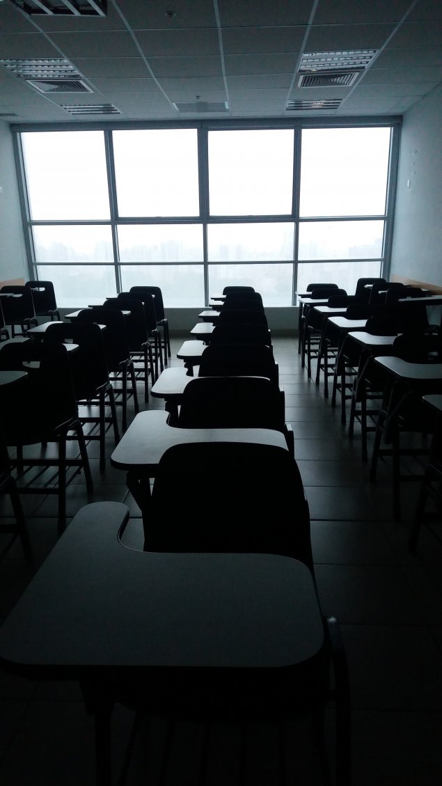 dark rows of desks in an empty classroom