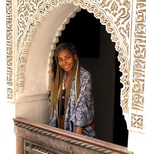 Maiya Coilton smiling next to an archway