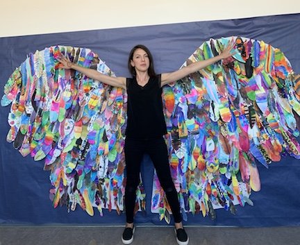 Sarah Allison smiling with butterfly wings created from student artwork