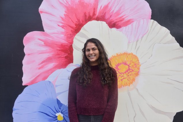 Rosy smiling with a flower mural background