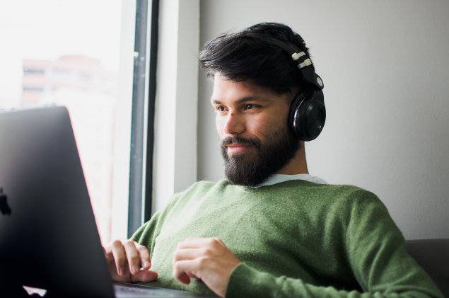 Man on laptop wearing headphones